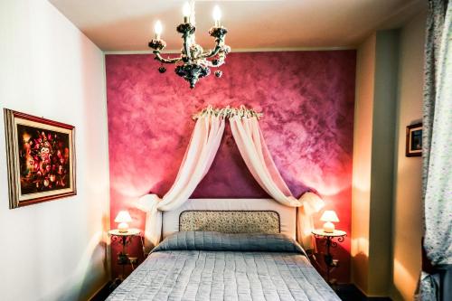1 dormitorio con 1 cama con pared de color rosa en Agriturismo Tenuta Polledro, en Asti