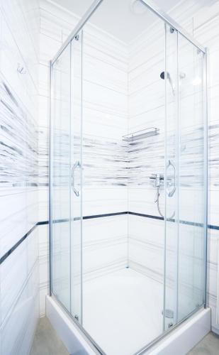 a glass shower in a bathroom with white walls at roomsy guest house in Sopot