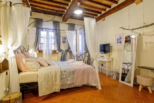 a bedroom with a bed and a television in it at Residenza d'Epoca La Rosa in Pienza