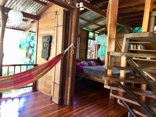 a hammock hanging in a room with a bed at Las Ranitas in Puerto Viejo