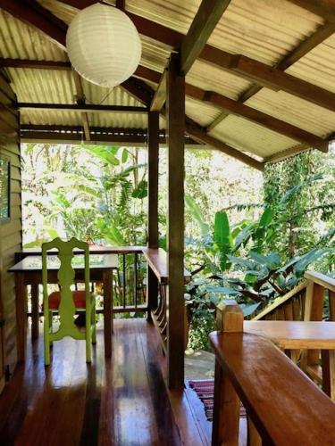 una sala da pranzo con tavolo e sedie su un portico di Las Ranitas a Puerto Viejo