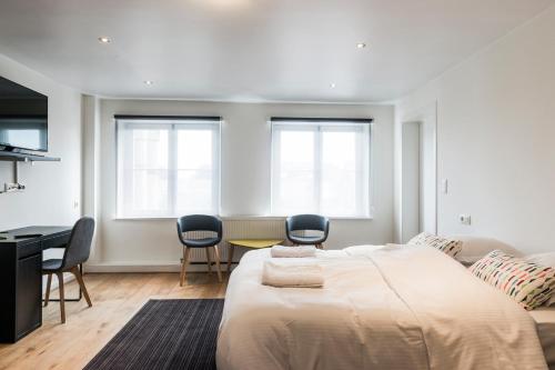 - une chambre avec un lit, une table et des chaises dans l'établissement Parkhotel Gent Centrum, à Gand