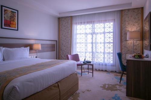 a hotel room with a bed and a desk and a window at Le Bosphorus Hotel - Waqf Safi in Al Madinah
