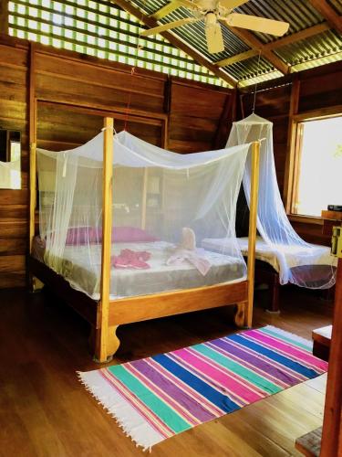 a bedroom with a bed with a mosquito net at Tranquila in Manzanillo