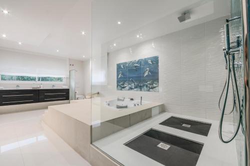 a white bathroom with a sink and a shower at Luxurious Villa Marly III to two minutes the beach in Castelldefels