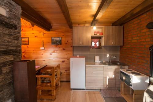 a kitchen with a white refrigerator and a table at Brvnara na bregu in Bajina Bašta