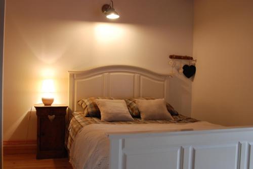 a bedroom with a bed with a lamp on a night stand at la source d'en haut in Valcivières