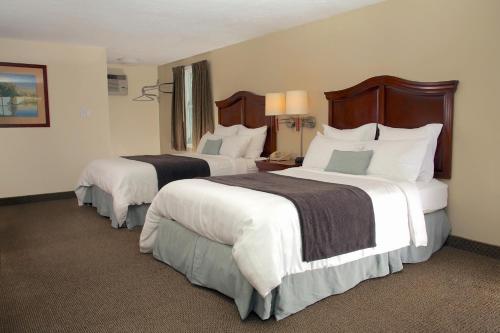 Vuode tai vuoteita majoituspaikassa Holiday Hill Inn & Suites