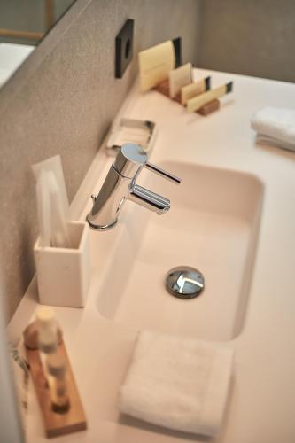 a bathroom sink with a faucet and towels at Ca n'Alexandre - Adults Only in Palma de Mallorca