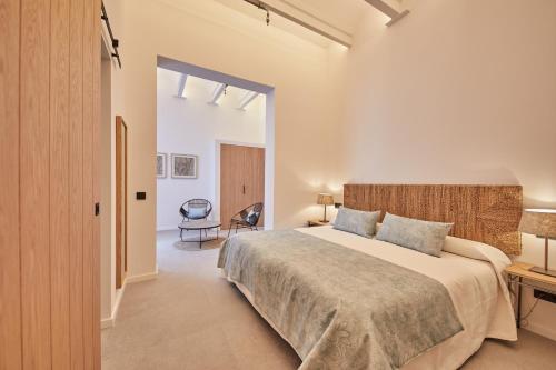 a bedroom with a large bed and a chair at Ca n'Alexandre - Adults Only in Palma de Mallorca