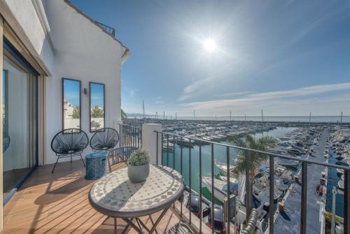 a balcony with a table and a view of a harbor at Penthouse in Puerto Banus in Marbella