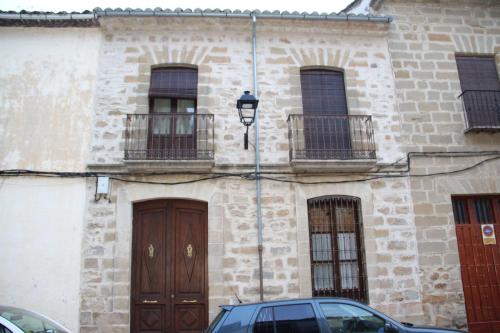 a building with two doors and a car parked in front at VTAR Casa las Tinajas in Baeza