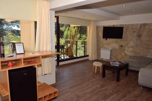 a living room with a large stone wall at Amarras in Villa Pehuenia