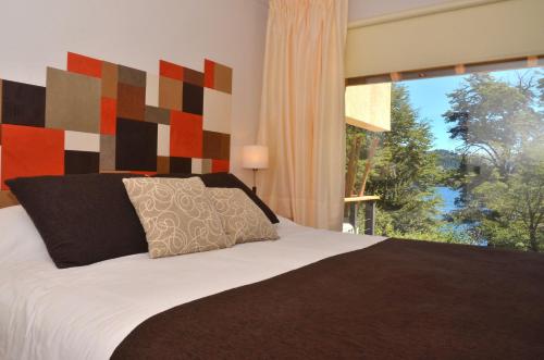 1 dormitorio con cama y ventana grande en Amarras en Villa Pehuenia