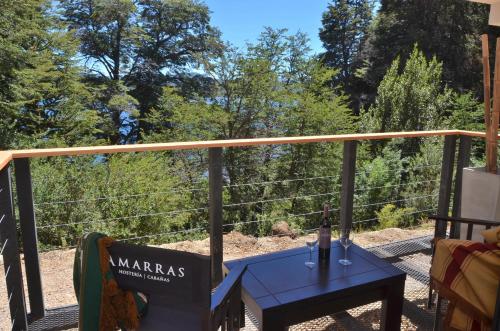 a table with a bottle of wine on a balcony at Amarras in Villa Pehuenia