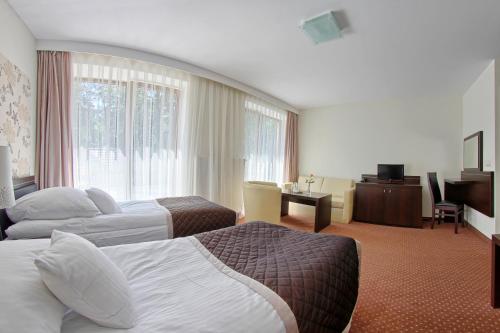 a hotel room with two beds and a television at Hotel Zacisze in Turawa