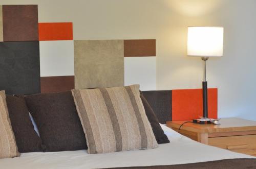 a bedroom with a bed with a lamp on a table at Amarras in Villa Pehuenia