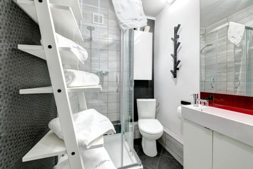 a white bathroom with a toilet and a sink at Prime Apartments - Lazurowa Przystań II in Sopot
