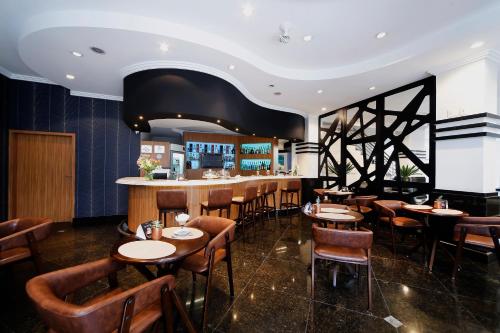 een restaurant met houten tafels en stoelen en een bar bij Grand Hotel Royal Sorocaba by Atlantica in Sorocaba