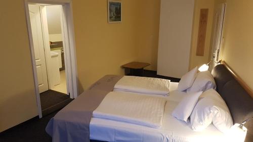 a bedroom with a bed with white sheets and pillows at Penzion Dolíček in Cheb