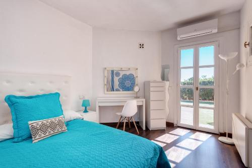 um quarto com uma cama azul e uma janela em Villa exclusiva con espectaculares vistas al Mediterráneo em Cala de Finestrat