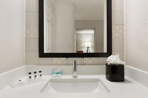 y baño con lavabo y espejo. en Country Inn & Suites by Radisson, Michigan City, IN, en Michigan City