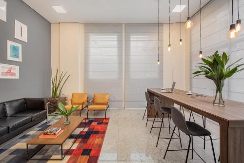 a living room with a long table and chairs at Intercity São Paulo Nações Unidas in Sao Paulo