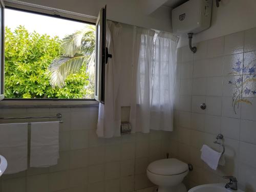 a bathroom with a toilet and a window at Villa Kalimera in Sorrento