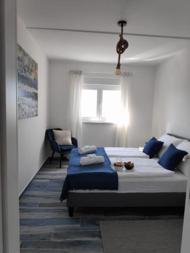 a bedroom with a large bed with blue sheets at Maristo Apartments in Stara Novalja