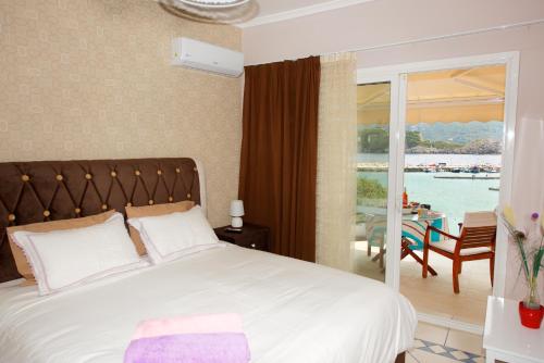 a bedroom with a bed and a view of the water at Napoleon On The Beach in Paleokastritsa