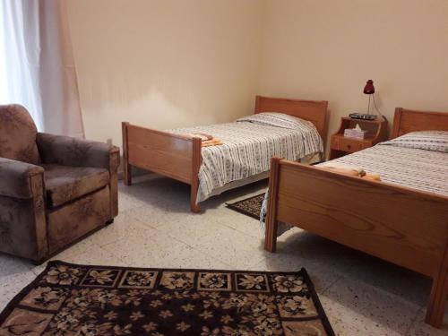 a bedroom with two beds and a chair and a couch at Chariandry Court in Pissouri