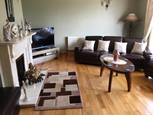 a living room with a couch and a table at Colmán House in Kilmihil