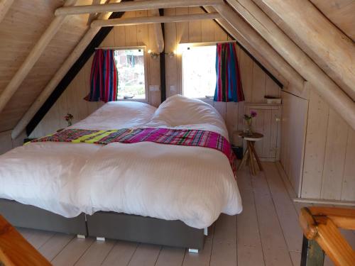een slaapkamer met 2 bedden op een zolder bij B&B Kupershof in Epe
