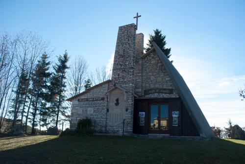 a small stone building with a cross on top of it at Alloggio Conca Dei Parpari in Rovere Veronese