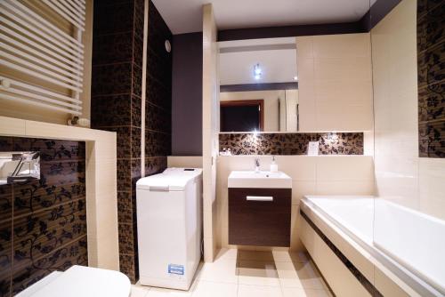 e bagno con lavandino, servizi igienici e vasca. di Apartments of Pawia a Cracovia