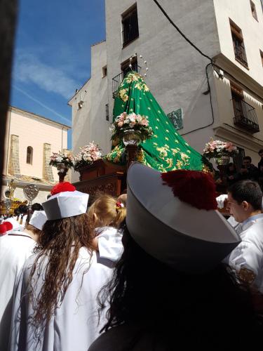 a group of people in white dresses and hats in a parade at Casa Botes in Cuenca