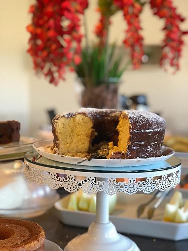 ein Kuchen auf einer Tortenplatte, bei dem ein Stück fehlt in der Unterkunft Cast Comfort Hotel in Paranaíba
