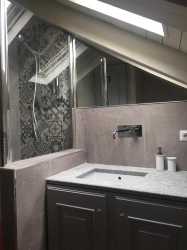 ein Bad mit einem Waschbecken und einem Spiegel in der Unterkunft la petite maison in Aosta