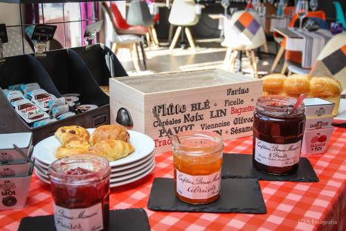 ein Tisch mit einem Teller Gebäck und einer Schachtel Essen in der Unterkunft Hotel Restaurant Kyriad Brive Centre in Brive-la-Gaillarde