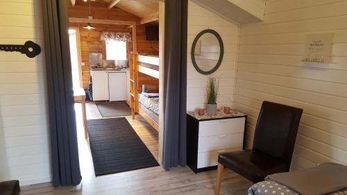 a tiny house hallway with a staircase and a mirror at Gripenbergs Gårdsbutik in Skänninge