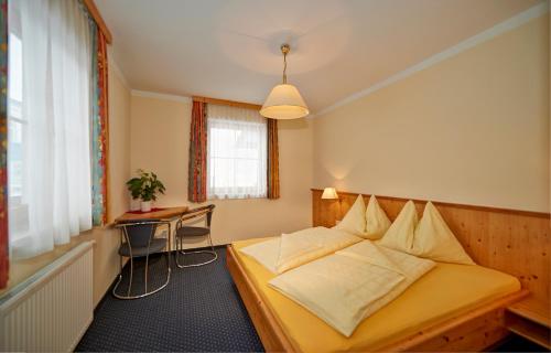 フラッハウにあるLärchenhofのベッドルーム1室(ベッド1台、テーブル、窓付)
