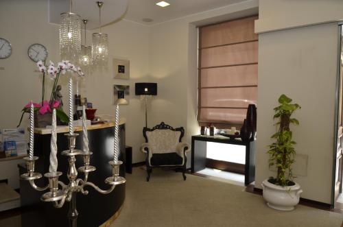 a living room with a chandelier and a chair at Cassisi Hotel in Milazzo