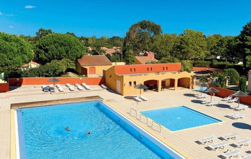 une grande piscine avec des chaises et un bâtiment dans l'établissement Les Albères Asclepieia Studio Ragnar, à Argelès-sur-Mer