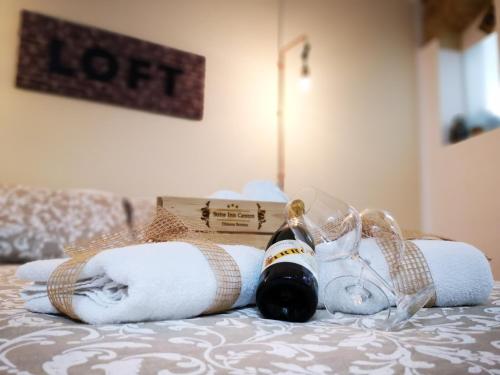 a bottle of wine and towels on a bed at Suite Inn Centro Dimora Storica in Enna