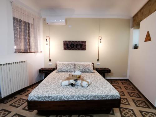 a bedroom with a bed with a teddy bear on it at Suite Inn Centro Dimora Storica in Enna