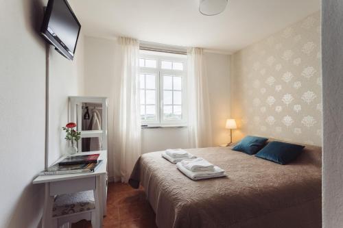 a small bedroom with a bed and a window at Conde Távora in Atouguia da Baleia