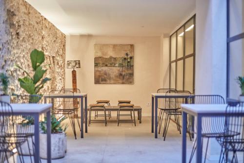a room with tables and chairs and a painting on the wall at Ca n'Alexandre - Adults Only in Palma de Mallorca
