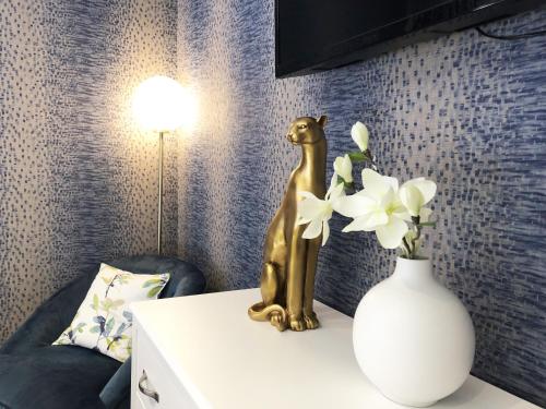 a gold dog statue next to a vase of flowers at Hotel Les Suites - Domaine de Crécy in Crecy la Chapelle