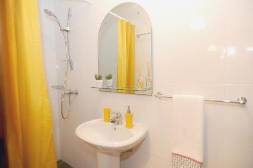 a white bathroom with a sink and a mirror at Apartamento Quinta do Faial in Funchal
