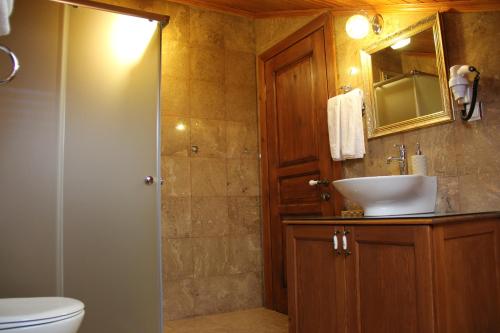 a bathroom with a sink and a toilet and a mirror at Konak Tuncel Efe in Datca